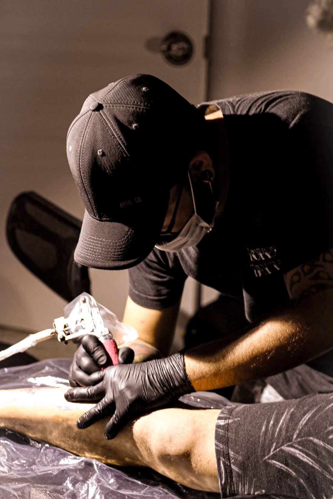Tatuador trabalhando em uma sessão na Lopes Tattoo