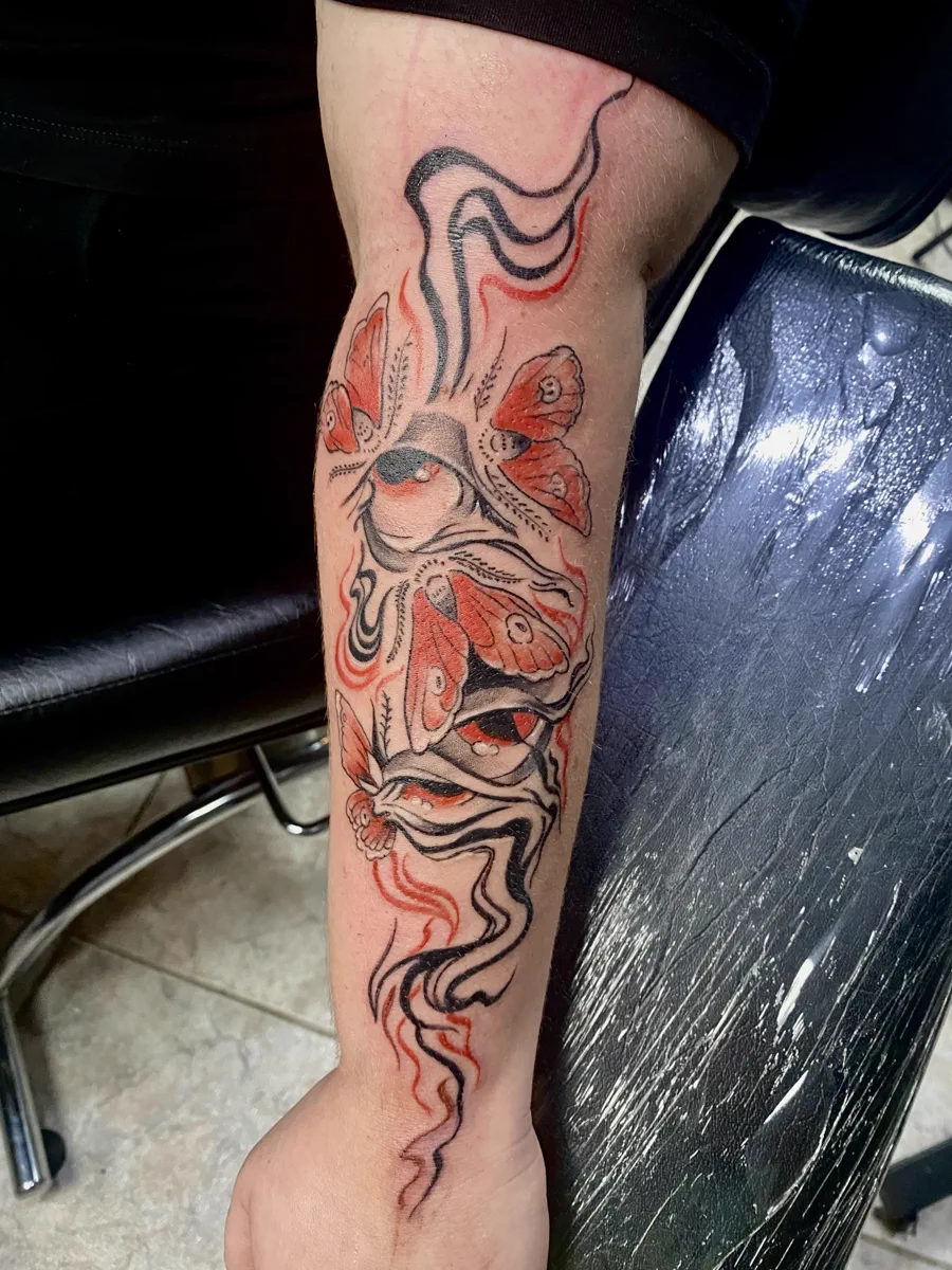 Tatuagem de borboletas em tons vermelhos realizada pela Lopes Tattoo